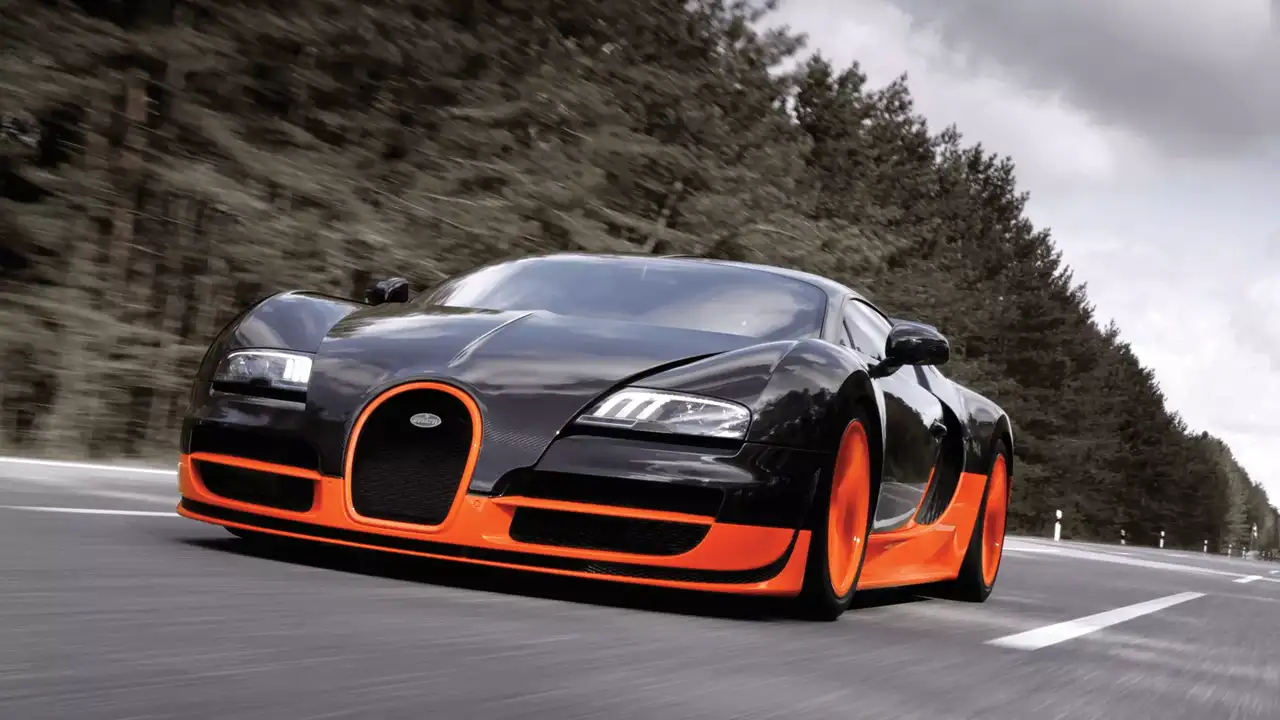 Bugatti Veyron Super Sport, a high-performance hypercar known for its top speed of 431 km/h, driving on a scenic road