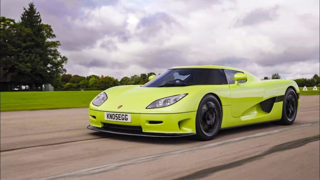 A vibrant lime green Koenigsegg CCR in motion on a test track, demonstrating its incredible speed and Swedish engineering prowess