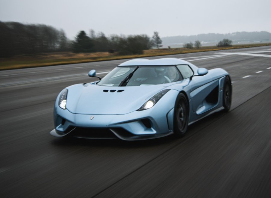 Koenigsegg Regera driving on a straight track, emphasizing its modern design and advanced technology