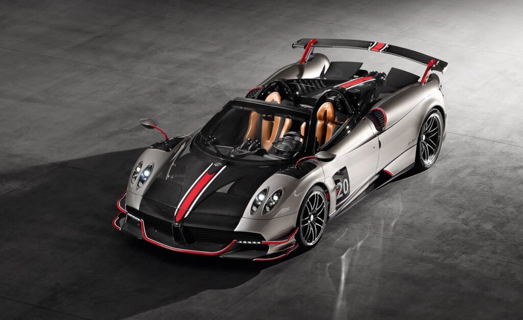 A metallic grey Pagani Huayra BC with red accents, showcasing its open-top design and engineering excellence