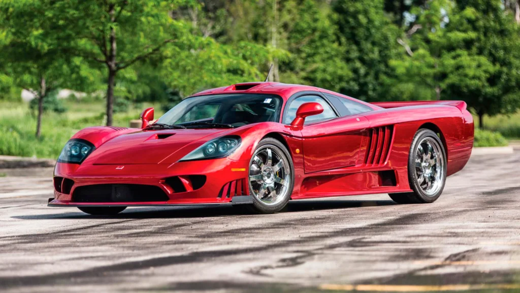 A striking red Saleen S7 Twin Turbo parked outdoors, showcasing its sleek aerodynamic design and iconic supercar features